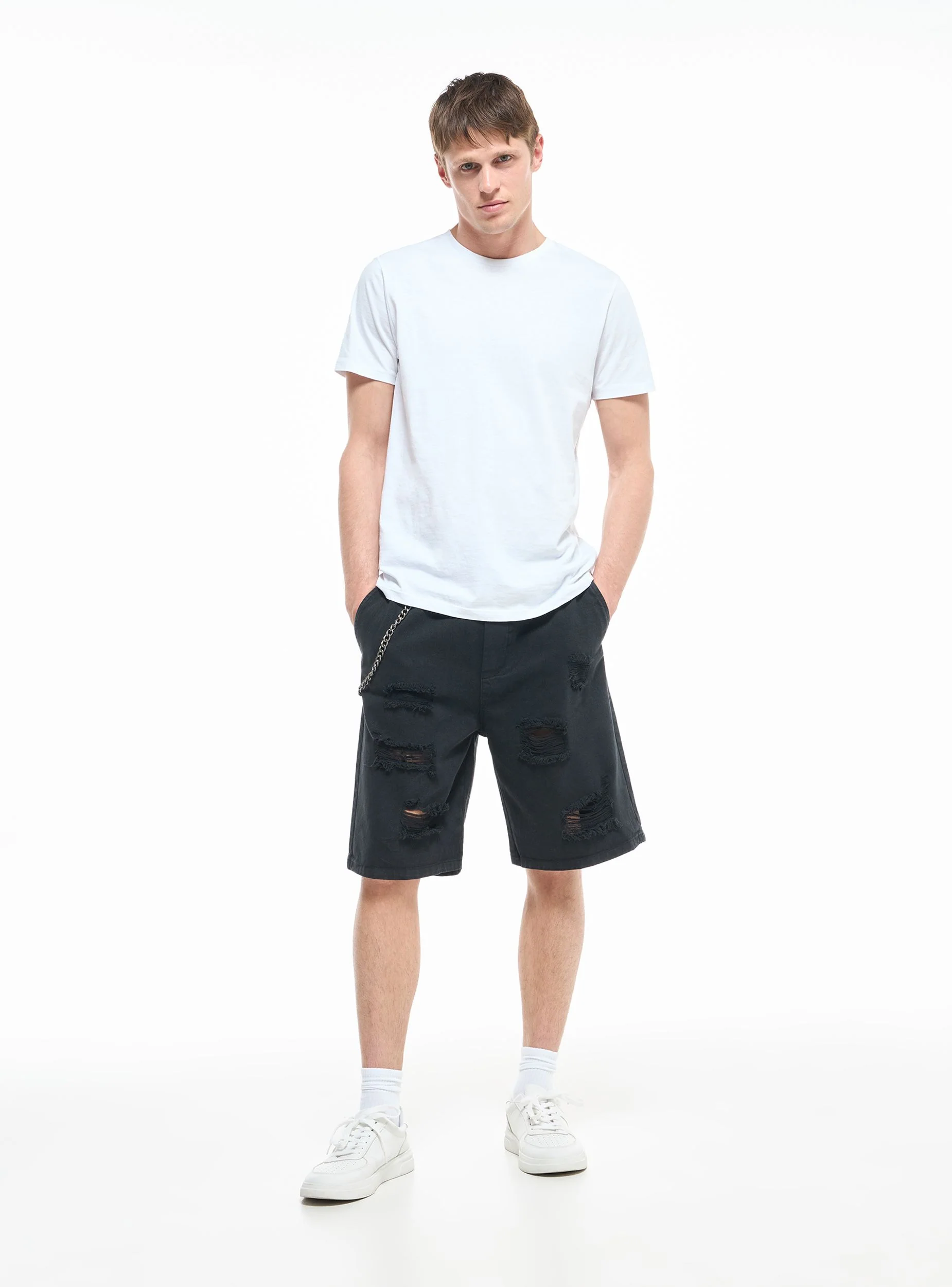 Pantaloncini con strappi e catena
