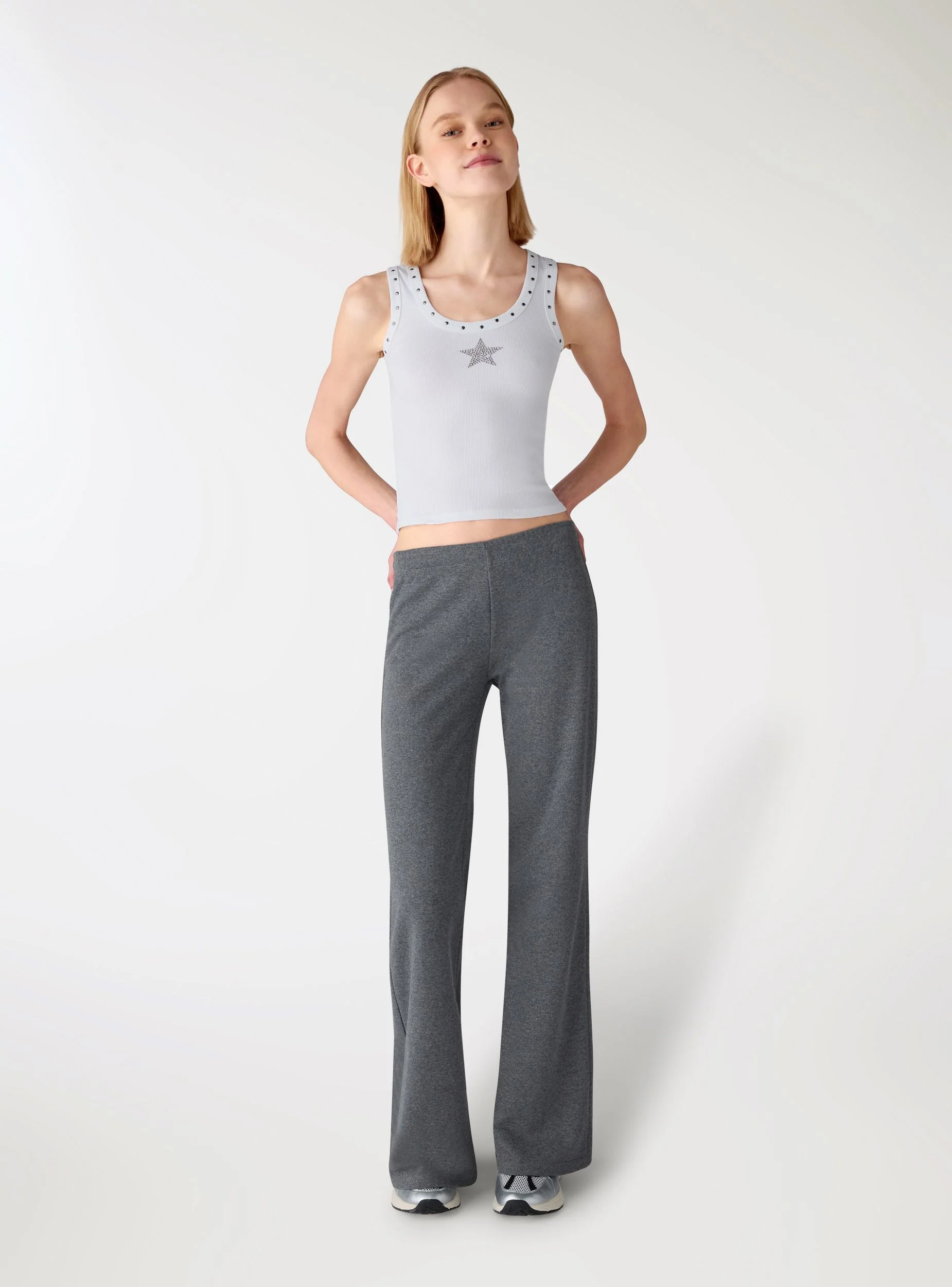 Top a costine con borchie e stella strass